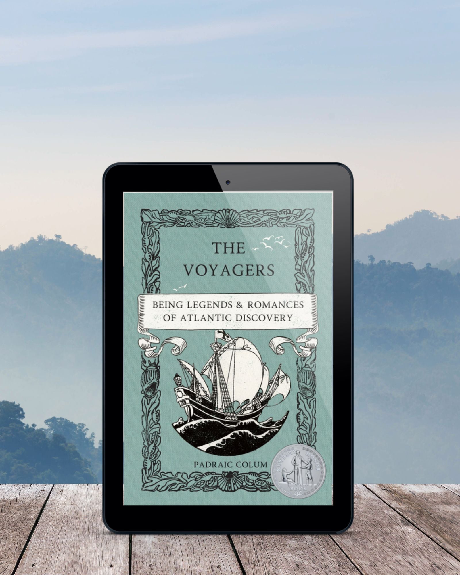 Black ereader featuring the teal cover of "The Voyagers: Being Legends & Romances of Atlantic Discovery" on grey wooden planks,  in front of a mountains cape.