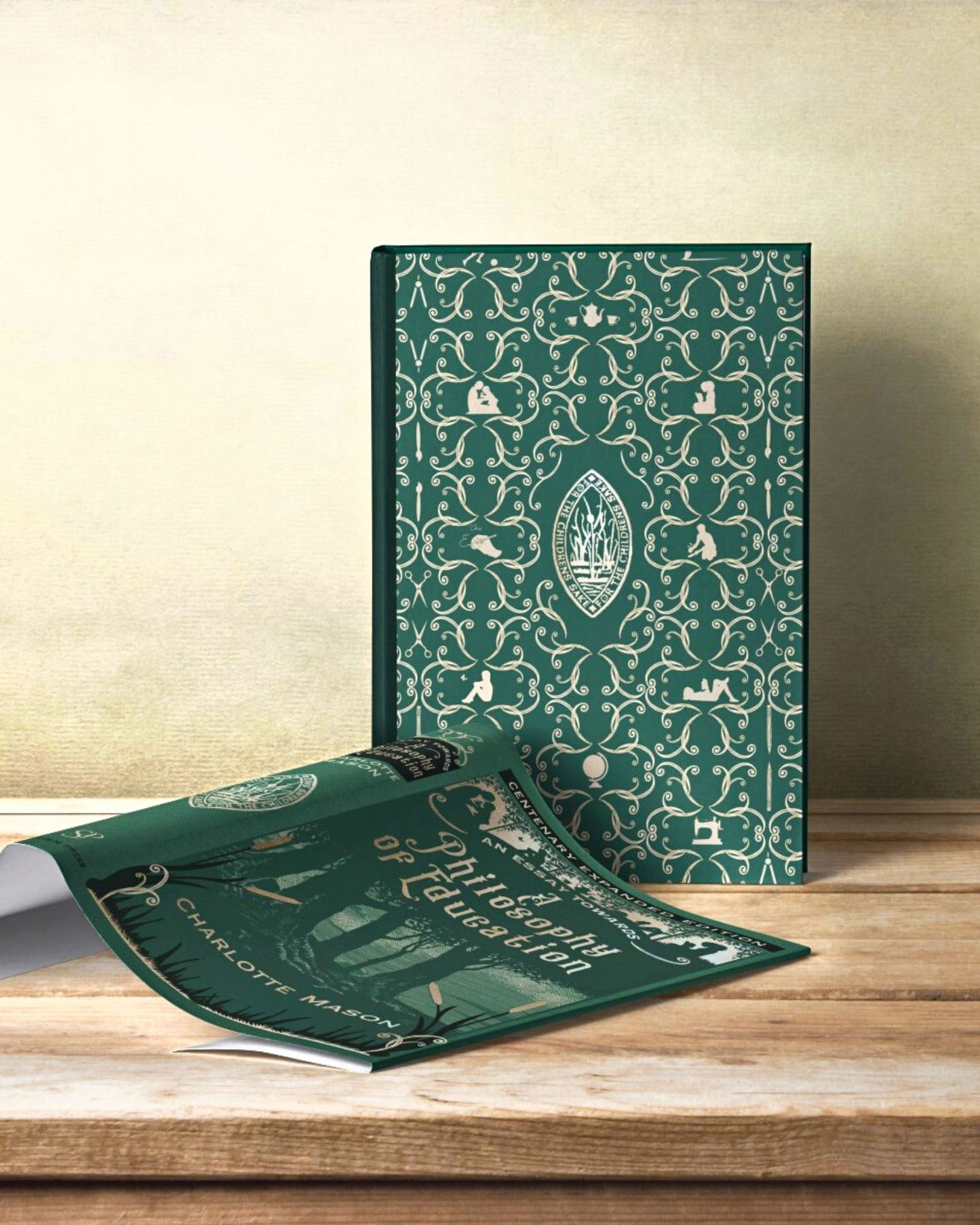 The hardback "An Essay Towards a Philosophy of Education" stands displaying its decorative inner cover with the beautiful green dust jacket lying on the blond table next to it.