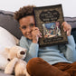 On a grey coach with a off-color throw pillow and blonde teddy bear snuggled close, a young black boy holds up an ornate copy of "The Story of the Other Wise Man."