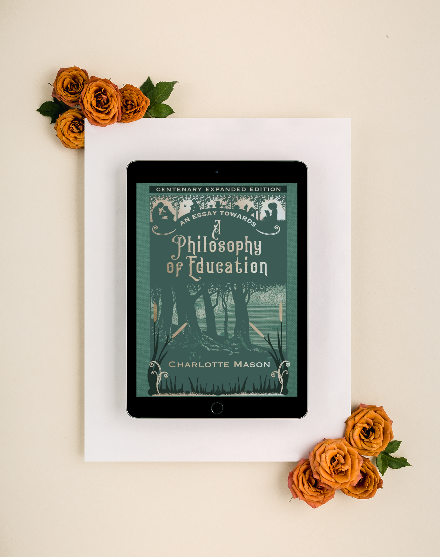 Tangerine colored roses crown the corners of a white page on which rests a tablet with the green ebook  "An Essay Towards a Philosophy of Education".